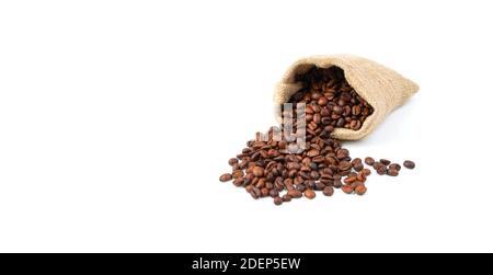 Renverser des grains de café dans un sac de lin isolé sur un fond blanc. Banque D'Images
