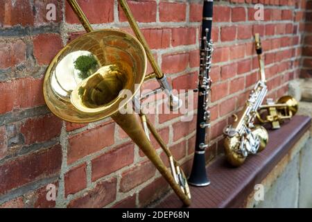 Instruments de musique dont clarinette trompette trombone et saxophone sur mur de briques à l'extérieur du club de jazz Banque D'Images