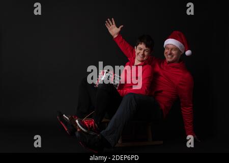 Santa sportif et Elf sur un traîneau avec boîte cadeau Banque D'Images