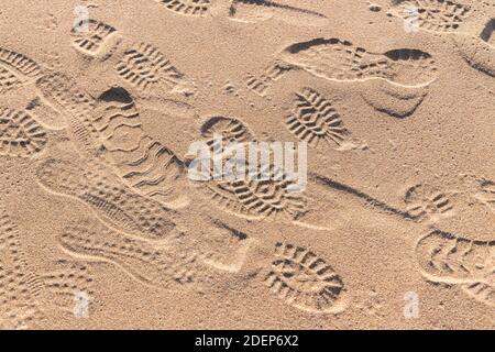 Empreintes de pieds dans le sable humide à la plage, texture de photo d'arrière-plan Banque D'Images