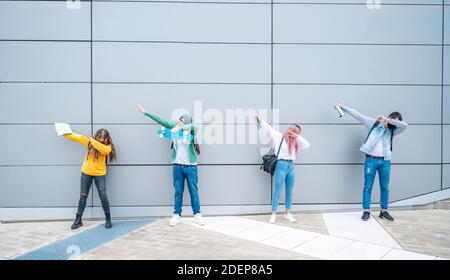 Heureux multiracial des amis adolescents dans des vêtements décontractés danse dub danse Sur fond de mur gris après l'école - Nouveau style de vie normal concept avec les jeunes Banque D'Images