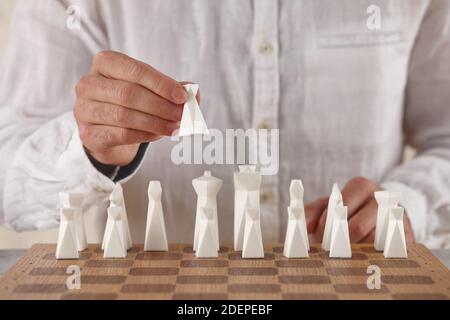 Homme jouant aux échecs, main vue rapprochée. Jeu de victoire. Banque D'Images