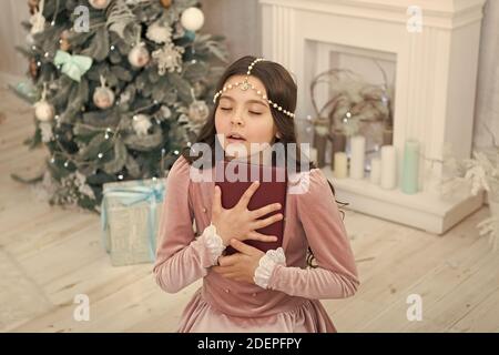 Se sentir reconnaissant. Esprit de Noël. Lecteur peu profiter de la lecture à la maison. Meilleur livre De Noël. Boutique Livres commerciaux. Peu de sourire enfant lire livre. Nouvel an. Petite fille lecture histoire de Noël. Banque D'Images