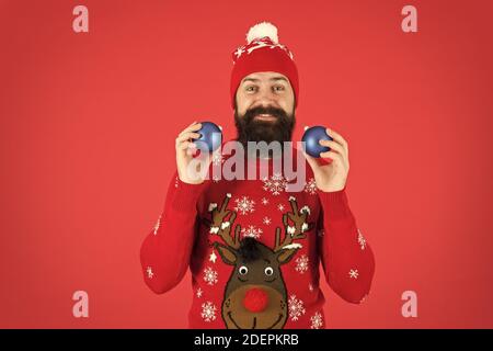 quelle est la couleur de noël. assistant de magasin de jouets. ambiance festive partout. jongleur bonne année. joyeux noël. plein de ressources et de drôles. homme heureux jonglant avec arbre décoratif jouet. Banque D'Images