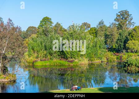 Un couple assis près d'un étang artificiel Royal Botanic Garden à Melbourne, Australie Banque D'Images