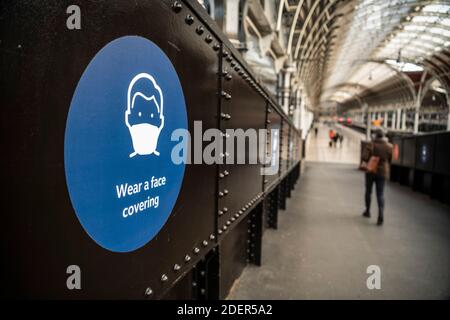 Coronavirus Covid-19 panneau d'information indiquant porter un masque facial à la gare de Paddington à Londres quand les transports en commun étaient calmes et désertés sans personne en Angleterre, en Europe Banque D'Images