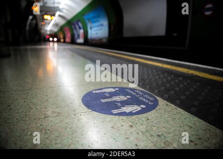 Le coronavirus Covid-19 enferme un panneau d'information et des conseils pour rester à 2 m de distance à Londres sur les transports publics à la station de métro en Angleterre, au Royaume-Uni Banque D'Images