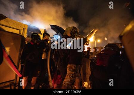 Un étudiant jette un cocktail Molotov à la police. À Hong Kong, le 12 novembre 2019. Une bataille sans précédent à l'Université chinoise de Hong Kong (CUHK). La manifestation de Hong Kong se continue sur ses cinq mois. Une grève à l'échelle de la ville a débuté le lundi 11 novembre 2019, ce qui a entraîné l'arrêt de certaines parties de Hong Kong lorsque les stations MTR ont fermé et que plusieurs barrages routiers ont été érigés. Où l'autoroute Tolo Harbour sous le pont n°2 qui relie l'Université chinoise de Hong Kong (CUHK) et l'espace public est également bloquée. Photo de May James/ABACAPRESS.COM Banque D'Images