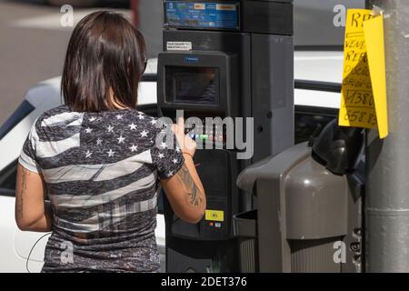 Madrid, Espagne - 26 septembre 2020 : après avoir entré le numéro de plaque d'immatriculation de la voiture, une femme paie le billet de stationnement réglementé par le Madrid c Banque D'Images