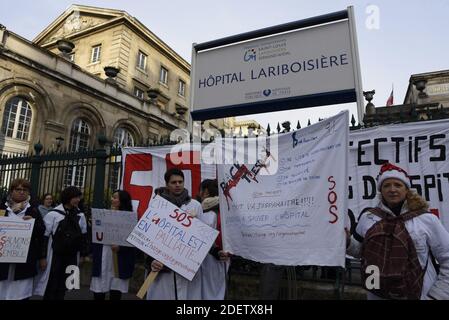 Les membres du personnel médical tiennent des écriteaux qui lisent « sauverons l'hôpital ensemble » et « frappent mes valeurs » lors d'un rassemblement à l'extérieur de l'hôpital Lariboisière à Paris, en France, le 17 décembre, 2019 manifester en faveur de l'hôpital public afin d'exiger plus de ressources pour l'hôpital dans le cadre d'une troisième journée nationale de manifestations multisectorielles sur une réforme des retraites gouvernementales, le gouvernement ne montrant aucun signe qu'il va céder aux demandes syndicales d'abandonner le plan. Les syndicats sont en grève depuis décembre 5 dans leur plus grande démonstration de force depuis des années contre les plans pour une seule pension Banque D'Images