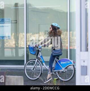 Une femme à vélo de location dans une rue de la ville de Vancouver, C.-B./Canada-novembre 1,2020. Vue sur la rue, photo de voyage, mise au point sélective. Banque D'Images