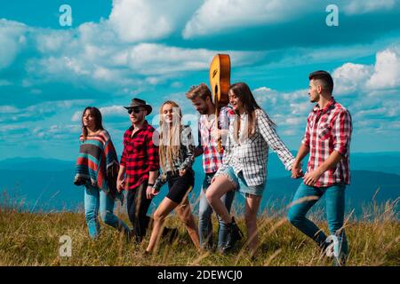 Groupe de personnes en plein air. Des groupes d'amis se détendent à l'extérieur de Tents Camping. Groupe d'adolescents magnifiques arrivant au festival d'été. Banque D'Images