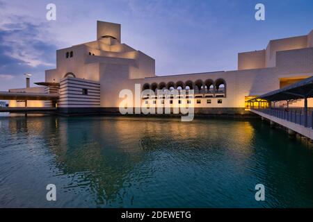 Musée d'art islamique, Doha, Qatar à la tombée de la nuit vue extérieure montrant l'architecture moderne du bâtiment avec réflexion lumineuse dans le golfe arabe et Banque D'Images