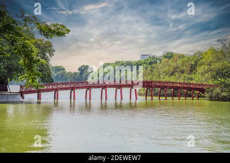 Le Pont rouge dans le jardin public de parc avec des arbres et réflexion au milieu du lac Hoan Kiem dans le centre-ville de Hanoi. Ville urbaine au coucher du soleil, Vietnam Banque D'Images