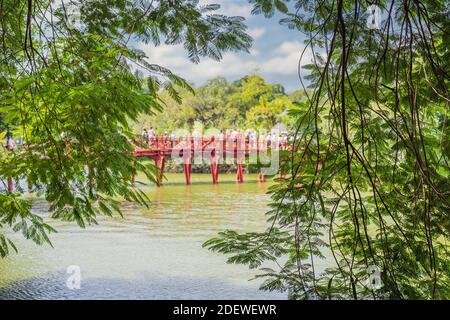 Le Pont rouge dans le jardin public de parc avec des arbres et réflexion au milieu du lac Hoan Kiem dans le centre-ville de Hanoi. Ville urbaine au coucher du soleil, Vietnam Banque D'Images