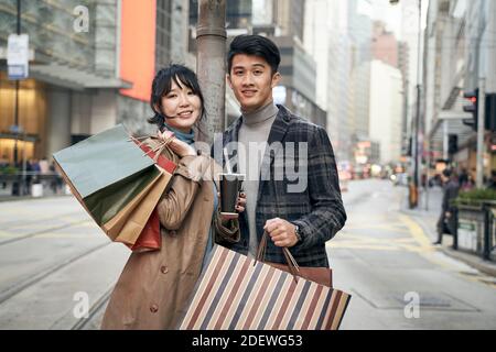 portrait extérieur d'un jeune couple asiatique avec des sacs à provisions en main Banque D'Images