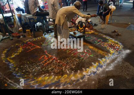 Mumbai / Inde 14 novembre 2020 Un vendeur de légumes indiens conçoit des rangoli de rue pendant le festival diwali est un rituel traditionnel parmi les affaires Banque D'Images