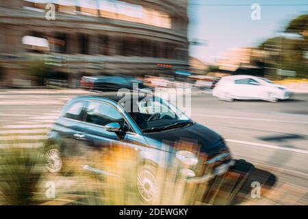 Rome, Italie. Fiat 500 en mouvement rapide flou près du Colisée. Banque D'Images