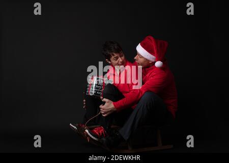 Santa sportif et Elf sur un traîneau avec boîte cadeau Banque D'Images