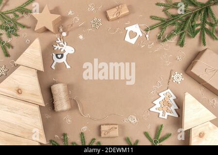 COMPOSITION NOËL ou nouvel an. Cadre, bordure faite de boîtes, ficelle, décoration en bois et branches d'épinette sur fond beige. Concept zéro déchet Banque D'Images
