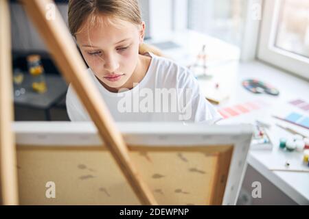 Jeune artiste concentré travaillant sur son image Banque D'Images