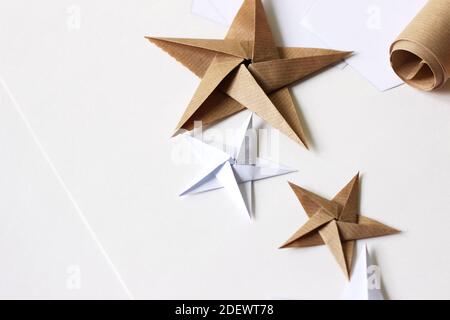 Créer des étoiles Origami de Noël pour la décoration. Arrière-plan de Noël minimal. Banque D'Images