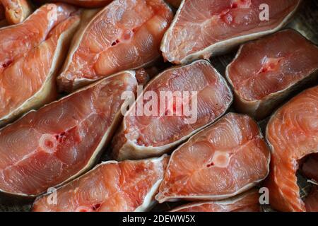 Des tranches de poisson rouge sont disposées en rangée. Résumé du saumon kéta ou saumon rose en gros plan. Toile de fond pour les produits du poisson Banque D'Images