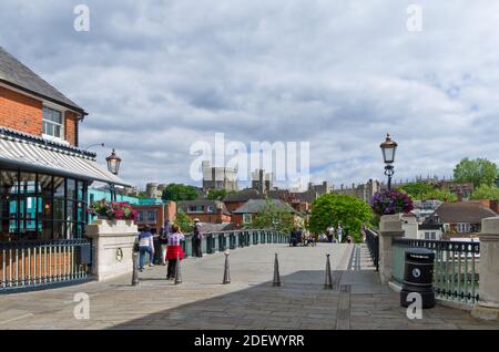 Passerelle piétonne au-dessus de la Tamise à Eton, Berkshire, Royaume-Uni; avec les tours du château de Windsor visibles au loin. Banque D'Images