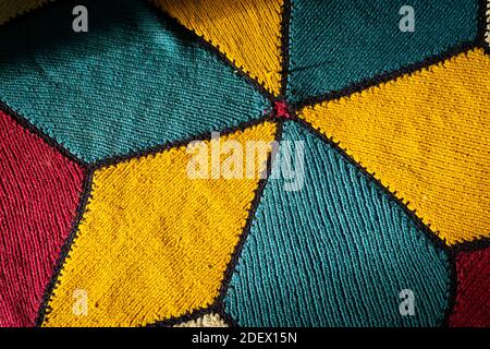 La lumière du soleil vient sur la main turque tapis tissé avec ombre. Tapis tissé à la main de couleurs jaune, bleu, rouge et blanc. Moquette traditionnelle artisanale colorée. Banque D'Images