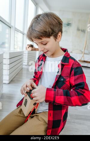 Garçon ouvrant Noël main calendrier de l'Avent dans une forme de maison pour compter les jours jusqu'à Noël dans la chambre. Banque D'Images