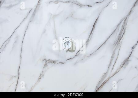 Vue de dessus du réveil blanc sur minuit ou douze sur blanc Banque D'Images