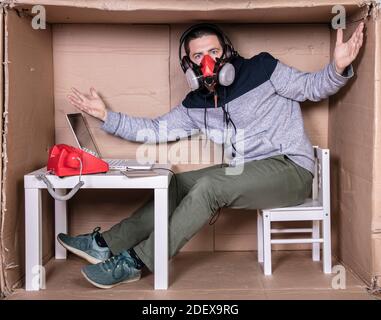 l'employé travaille depuis son propre bureau de carton pour s'isoler des autres Banque D'Images