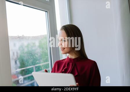 Photo d'une jeune femme heureuse et joyeuse à l'intérieur à la maison utilisation d'un ordinateur portable parlant par téléphone portable Banque D'Images