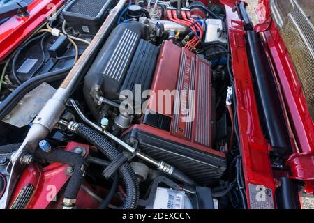 Gros plan du moteur turbocompressé de 2 litres à 16 soupapes dans une Lancia Delta HF Integrale Evoluzione rouge, montrant le renfort de jambe de force en aluminium. Banque D'Images