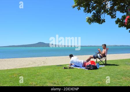 AUCKLAND, NOUVELLE-ZÉLANDE - 28 novembre 2020 : vue sur les personnes à la plage de St Heliers Bay avec l'île Rangitoto en arrière-plan Banque D'Images