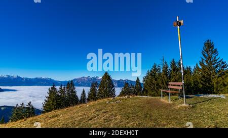 Bank auf dem Alpkopf, mit Aussicht auf die Schweizer Berge, über das vernebelte Rheintal. banc de parc au sommet de la montagne, sur mer de brume Banque D'Images