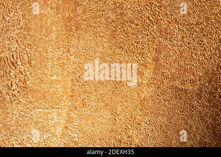 Texture de feuille de cuivre doré froissés, vue de dessus, gros plan sur fond de texture de feuille d'or jaune brillant Banque D'Images