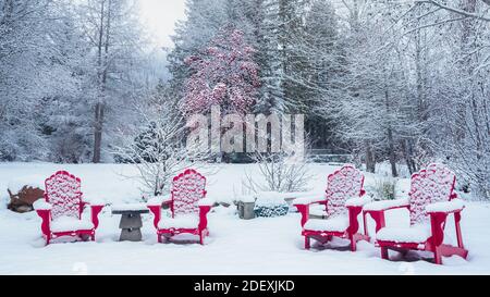 Des couvertures de neige fraîches des chaises en bois rouge pour créer un charmant scène d'hiver Banque D'Images