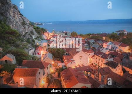 Vue sur la ville côtière d'omis, Croatie pendant l'heure bleue. Banque D'Images
