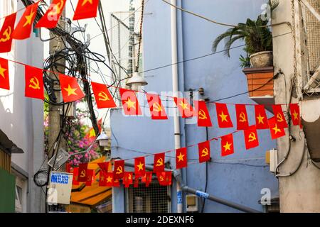 Banderole de drapeaux vietnamiens d'une étoile jaune sur fond rouge et marteau et faucille, Ho Chi Minh ville, Vietnam, Asie Banque D'Images