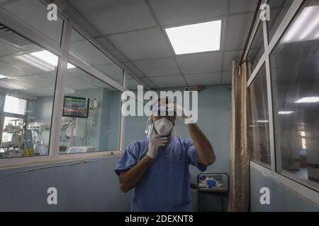 Gaza, Territoires palestiniens. 02e décembre 2020. Un médic met sur son écran facial à l'unité de soins intensifs du coronavirus de l'hôpital de Shifa. Credit: Mohammed Talatene/dpa/Alay Live News Banque D'Images