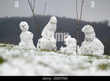 Balkhausen, Allemagne. 02e décembre 2020. Quatre bonhommes de neige se trouvent sur un champ enneigé près de Balkhausen, dans le parc naturel Bergstraße/Odenwald. Juste à temps pour le début météorologique de l'hiver le 1er décembre, la neige a transformé Hessen en un pays merveilleux d'hiver. Credit: Arne Dedert/dpa/Alay Live News Banque D'Images