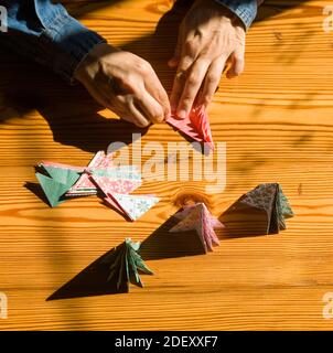 Création de décorations de cadeaux de Noël avec arbres de Noël. Fabriqué avec vos propres mains. Vue de dessus d'une table en bois avec les mains des femmes. Artisanat de loisirs pour WO Banque D'Images