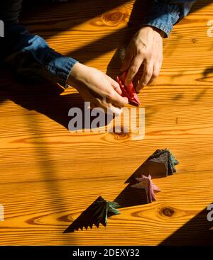 Création de décorations de cadeaux de Noël avec arbres de Noël. Fabriqué avec vos propres mains. Vue de dessus d'une table en bois avec les mains des femmes. Artisanat de loisirs pour WO Banque D'Images