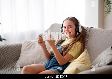 Fille portant un casque pour écouter de la musique avec un téléphone Banque D'Images