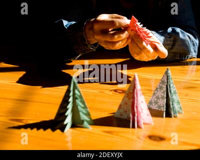 Création de décorations de cadeaux de Noël avec arbres de Noël. Fabriqué avec vos propres mains. Vue de dessus d'une table en bois avec les mains des femmes. Artisanat de loisirs pour WO Banque D'Images