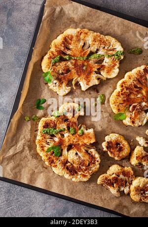 Steaks de chou-fleur avec des herbes et épices sur plaque de cuisson pour les substituts de viande à base de plantes Banque D'Images