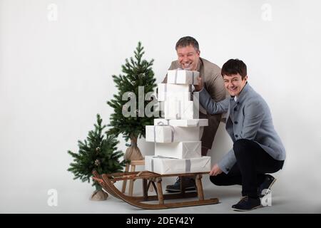 Thème de Noël horizontal couple portrait habillé élégant décontracté en bleu, blanc, beige pantalon et blazers sur fond gris. Banque D'Images
