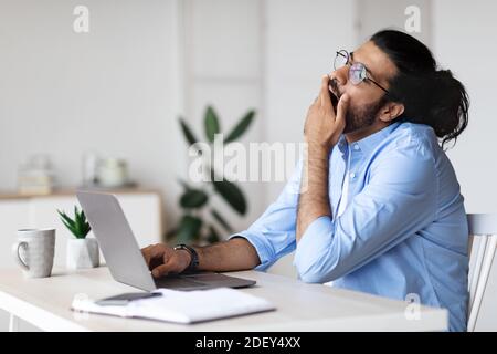 Expert freelance Sleepy bâillant au bureau à domicile, fatigué du travail Banque D'Images