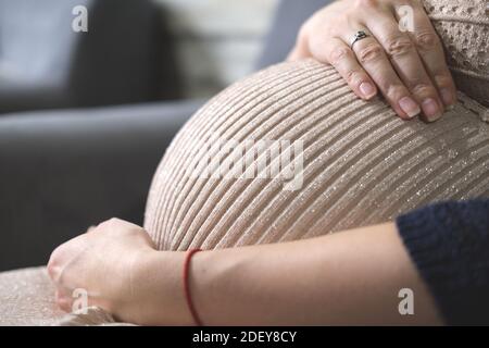 Femme enceinte en beige belle robe, femme enceinte ventre Banque D'Images